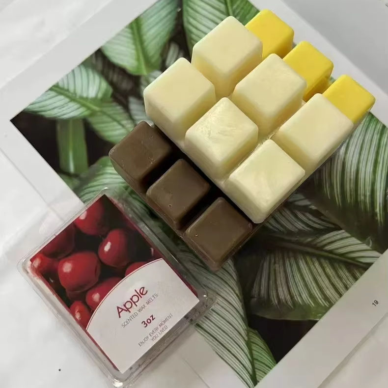 Scented wax melt cubes in cream, yellow and brown in a clamshell tray with a retail label